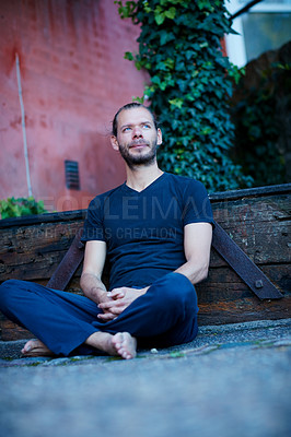 Buy stock photo Shot of a man sitting against a wall outside