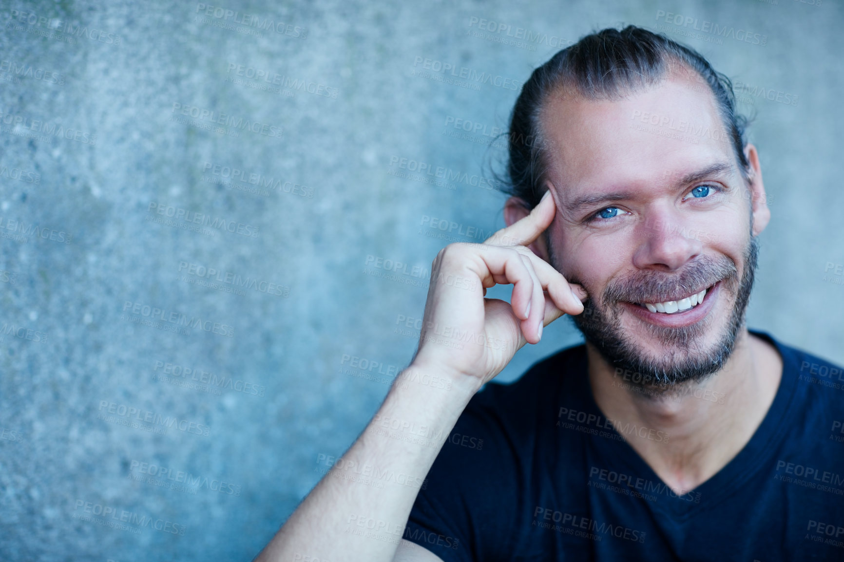 Buy stock photo Portrait of a man sitting against a wall outside