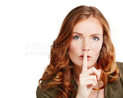 Buy stock photo Studio shot of a young woman posing with her finger on her lips