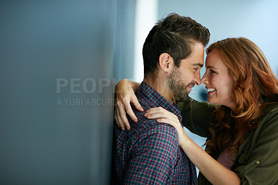 Buy stock photo Shot of a happy young couple leaning against a blackboard