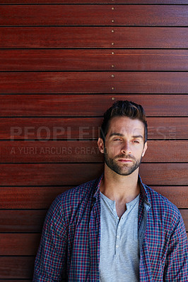 Buy stock photo Shot of a handsome man standing against a wooden wall