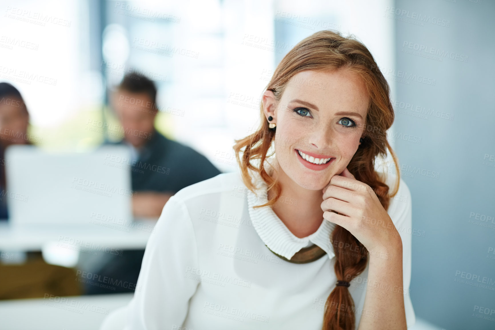 Buy stock photo Portrait of a young businesswoman sitting in an office with colleagues in the background