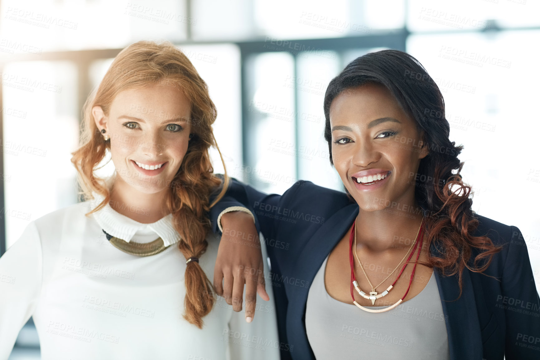 Buy stock photo Portrait of two young businesswomen standing together in an office