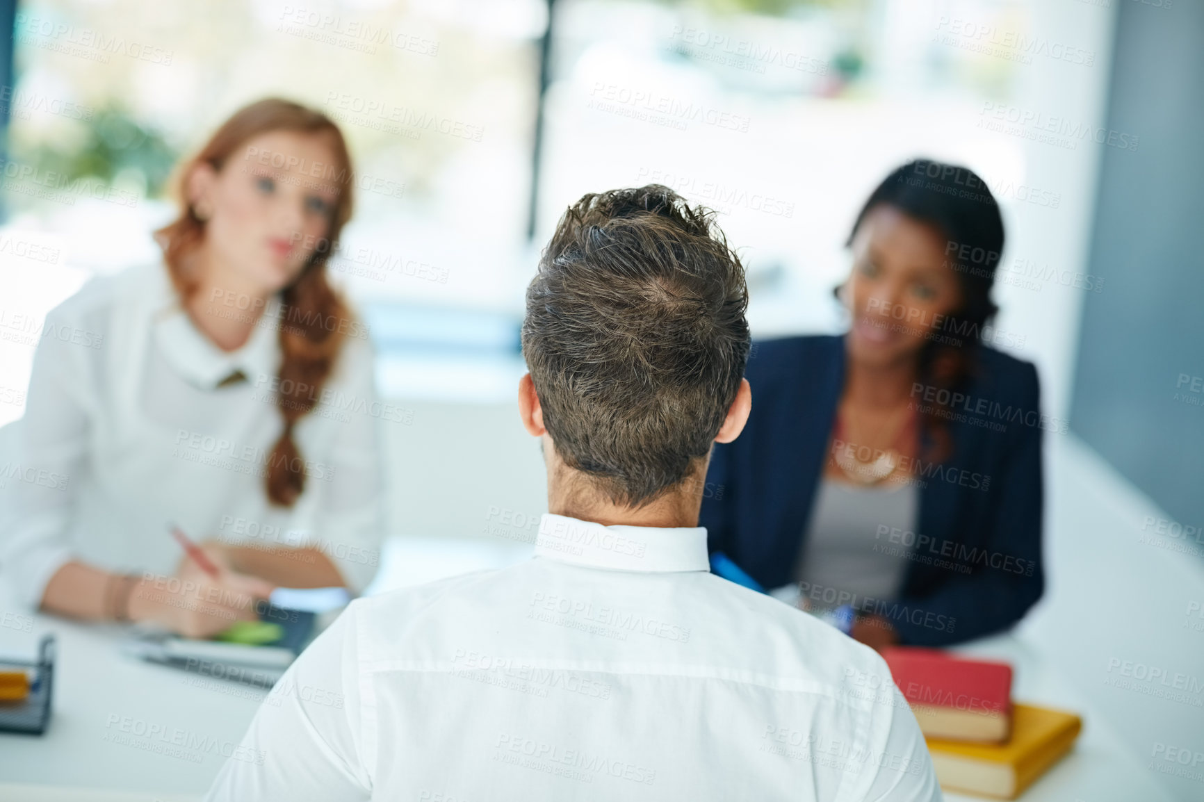 Buy stock photo Cropped shot of a man being interviewed by two businesswomen in an office