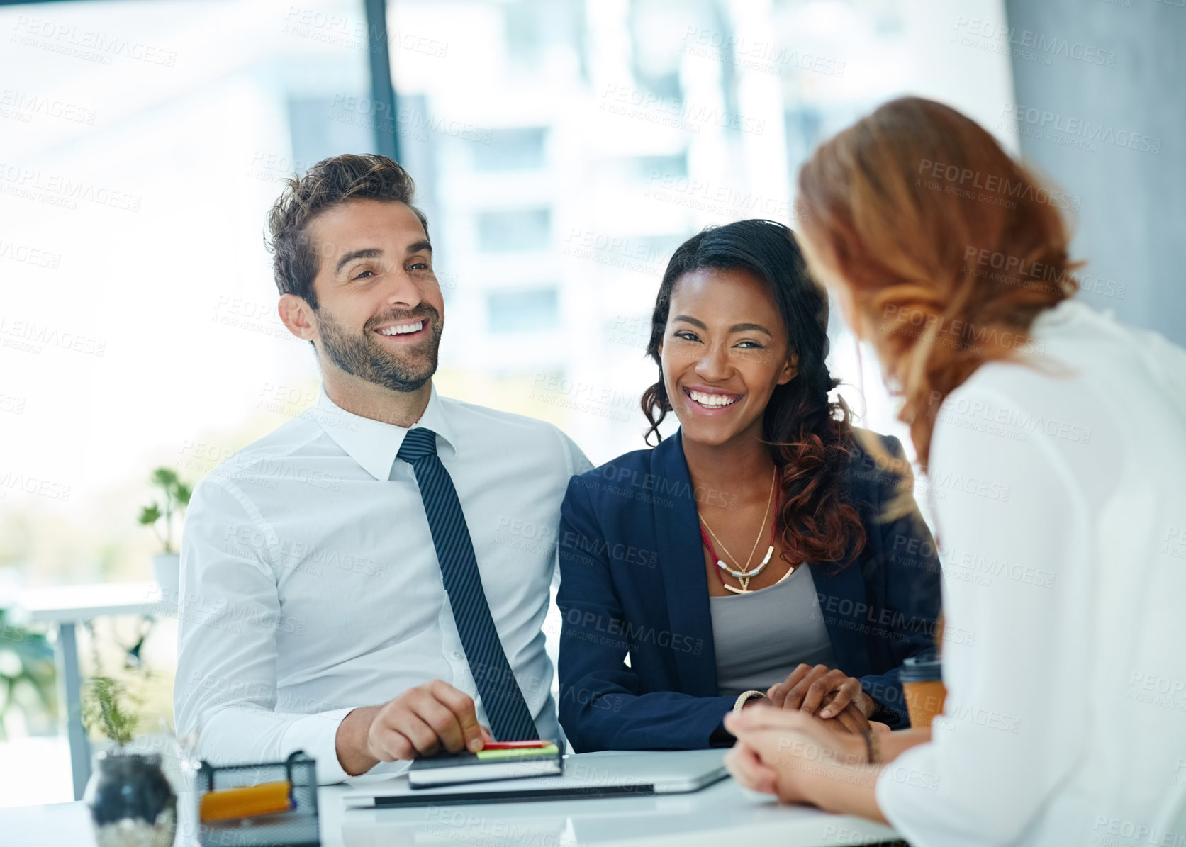 Buy stock photo Cropped shot of a young couple meeting with their advisor in an office