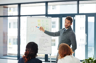 Buy stock photo Cropped shot of a young businessman giving a presentation to his colleagues in an office