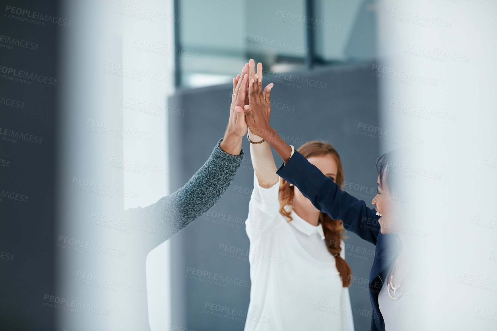 Buy stock photo Cropped shot of colleagues high fiving together in an office