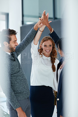 Buy stock photo Cropped shot of colleagues high fiving together in an office