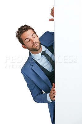 Buy stock photo Studio shot of a handsome businessman peering around a wall against a white background