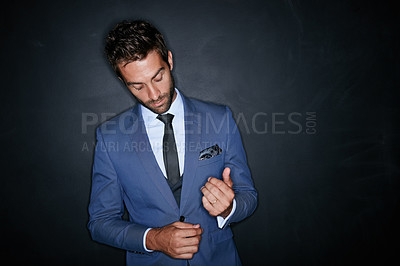 Buy stock photo Studio shot of a handsome young man standing against a dark background