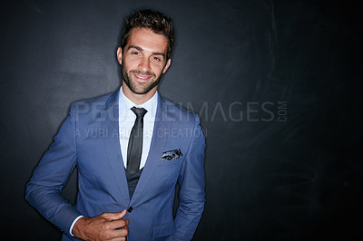 Buy stock photo Studio portrait of a handsome young man standing against a dark background