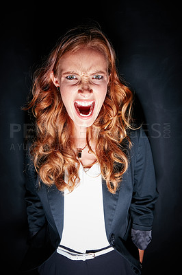 Buy stock photo Studio portrait of a young woman making a crazy face against a dark background