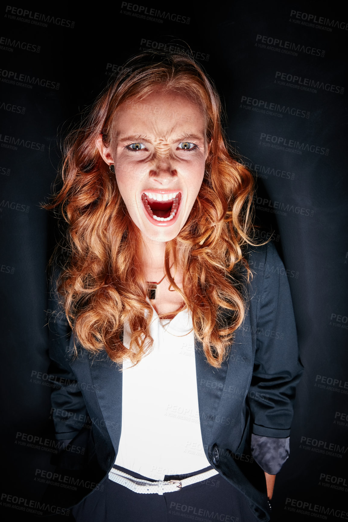 Buy stock photo Studio portrait of a young woman making a crazy face against a dark background