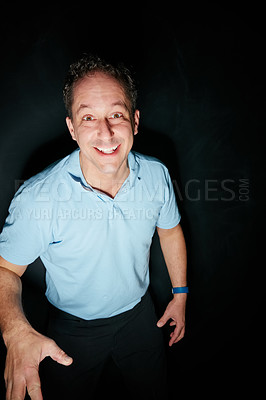 Buy stock photo Studio portrait of an expressive man smiling against a dark background