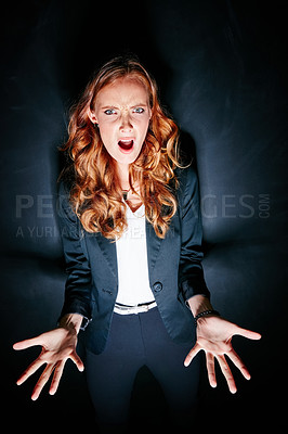Buy stock photo Studio portrait of a shocked looking young woman standing against a dark background