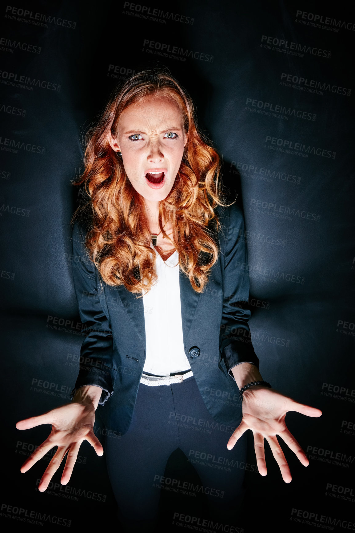 Buy stock photo Studio portrait of a shocked looking young woman standing against a dark background