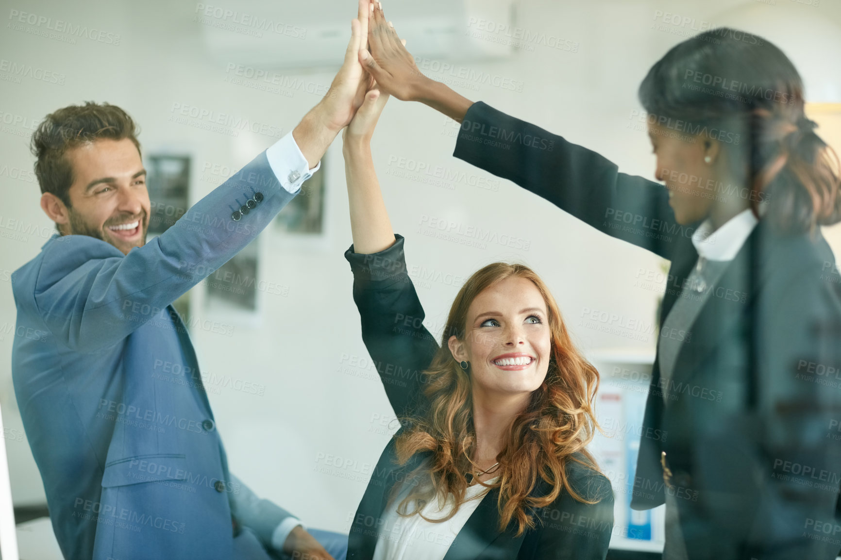 Buy stock photo Cropped shot of colleagues high fiving together in an office