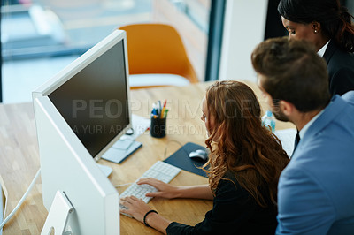 Buy stock photo Cropped shot of colleagues working together on a computer in an office