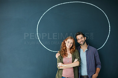 Buy stock photo Portrait of a young couple standing in front of a blackboard with a circle drawn around them