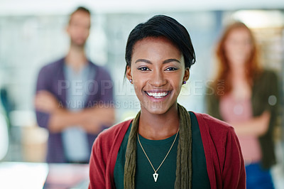 Buy stock photo Portrait of a happy young businesswoman with her colleagues in the background