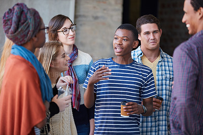 Buy stock photo Cropped shot of a group of university students socialising on campus