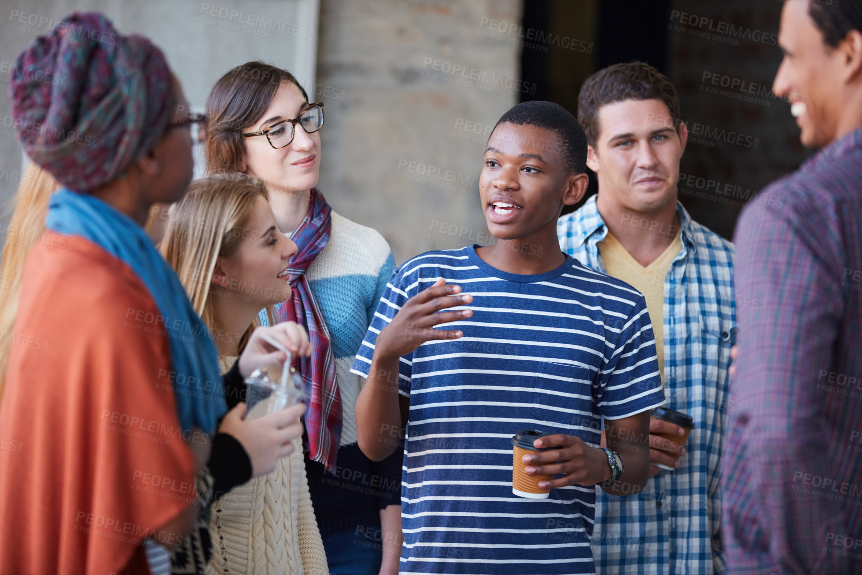 Buy stock photo Cropped shot of a group of university students socialising on campus