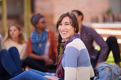 Buy stock photo Shot of a group of young friends relaxing outside on campus