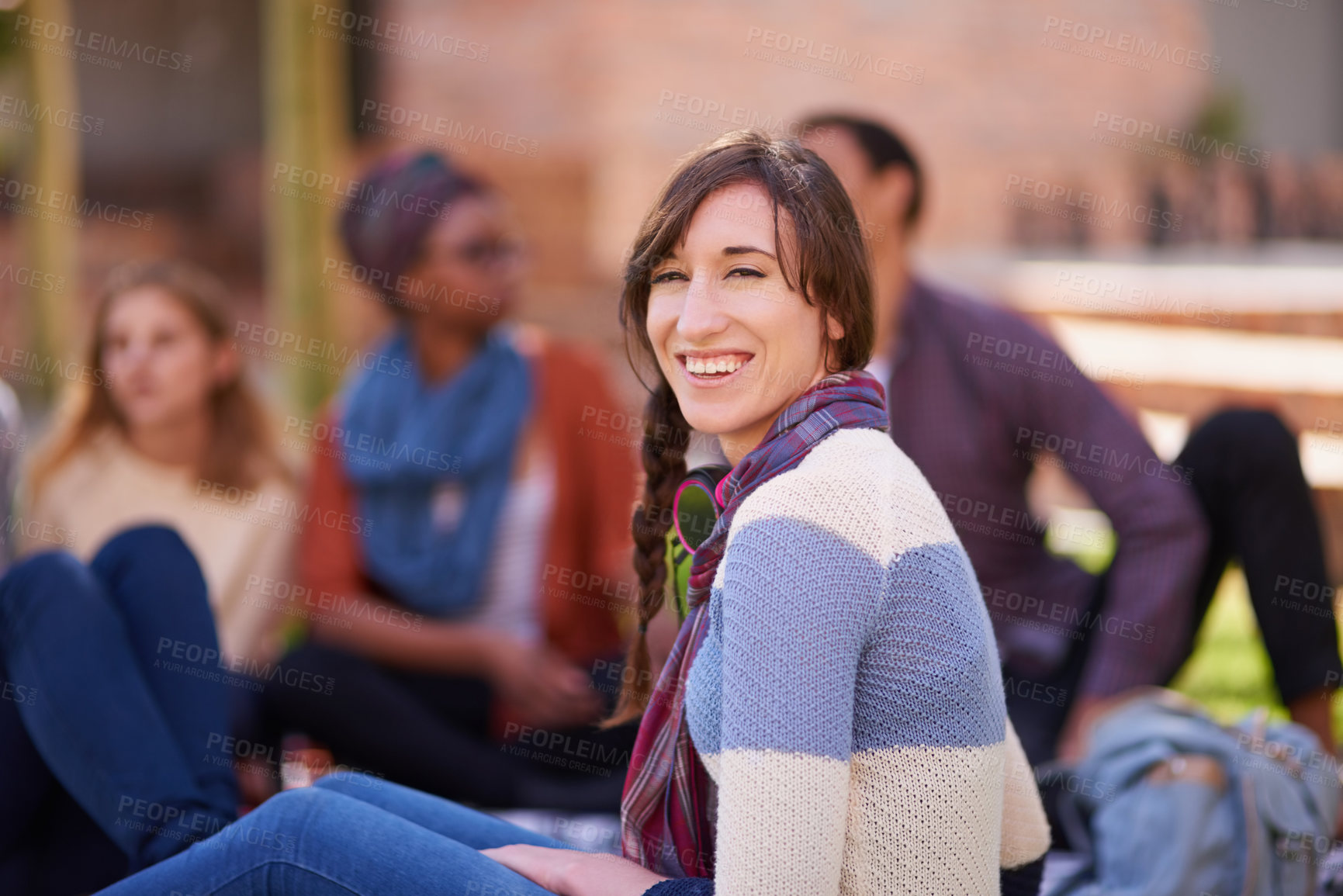 Buy stock photo Shot of a group of young friends relaxing outside on campus