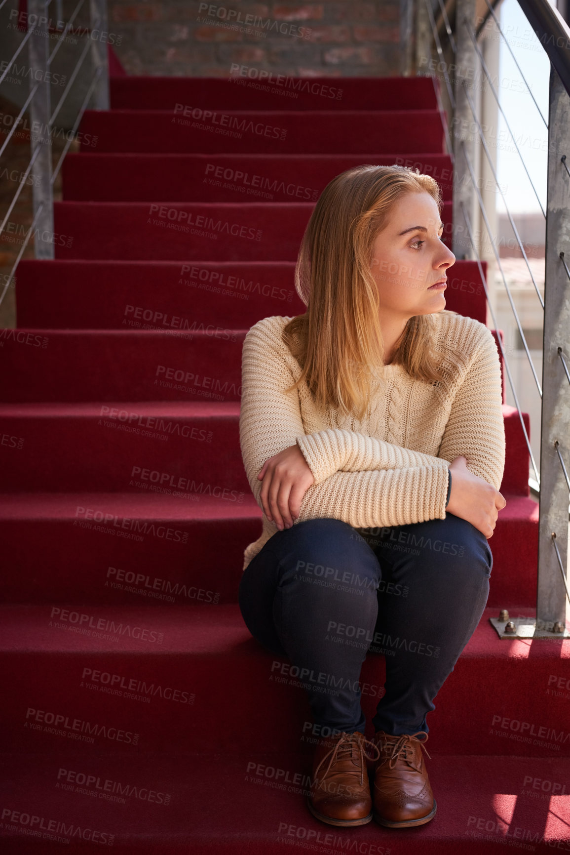 Buy stock photo Cropped shot of a university student sitting on a staircase at campus
