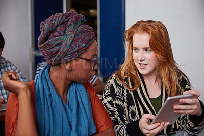 Buy stock photo Cropped shot of two university students having a discussion on a digital tablet in class