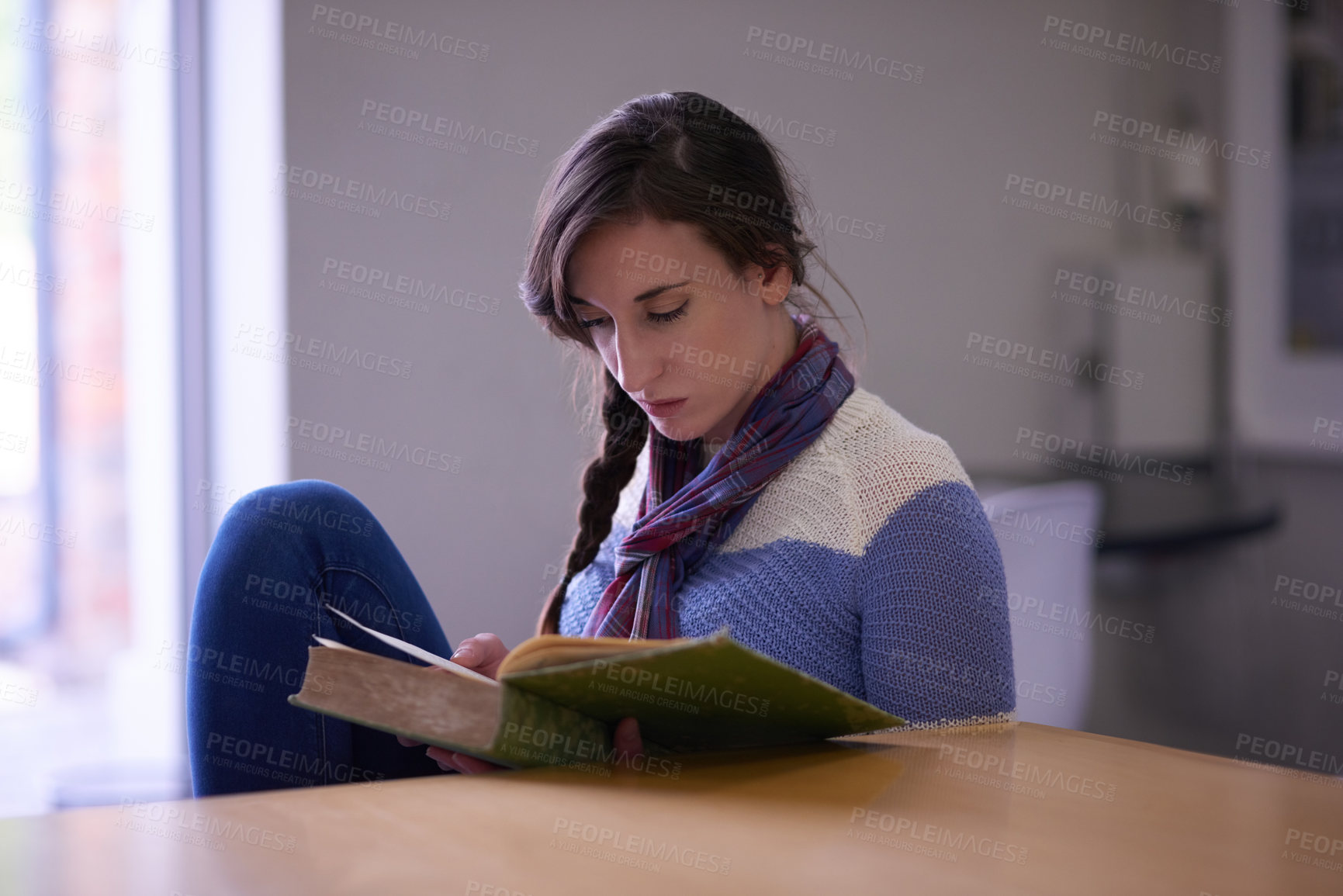 Buy stock photo Cropped shot of a university student reading a book on campus