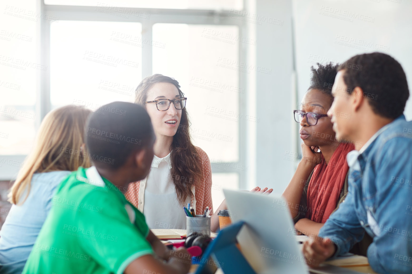 Buy stock photo Shot of a group of university students working on a group project in class