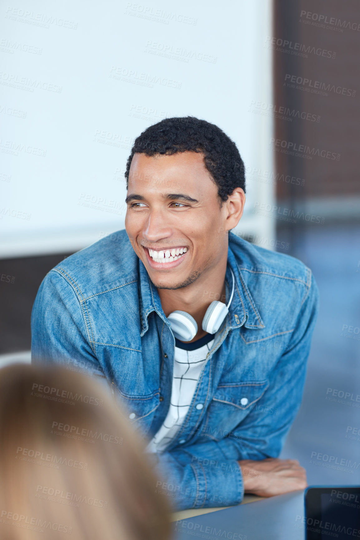 Buy stock photo Shot of a young university student sitting in his classroom during a group project