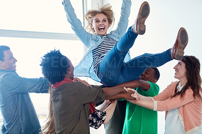Buy stock photo Shot of a group of university students tossing another student in their air during class