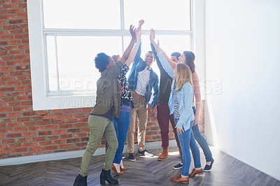 Buy stock photo Shot of a group of university students high fiving one another during class