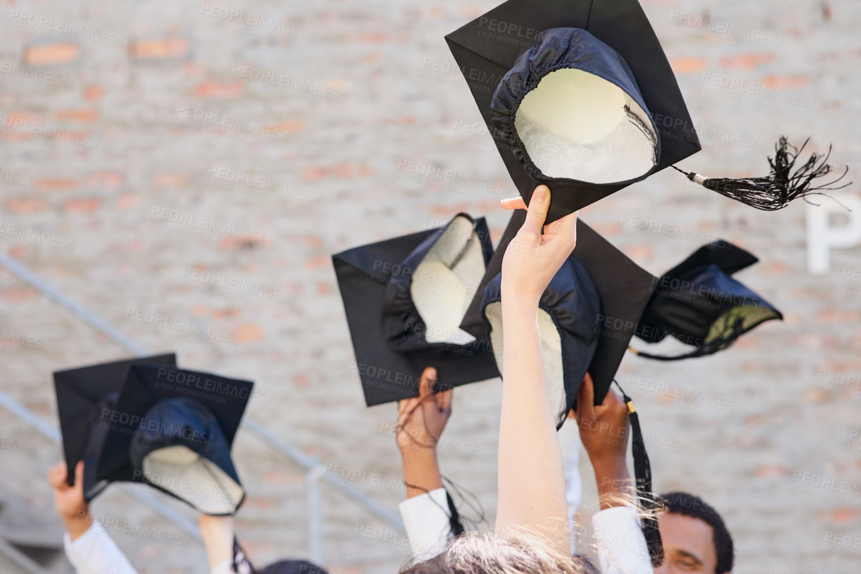 Buy stock photo Shot of a group of students throwing their caps into the air on graduation day