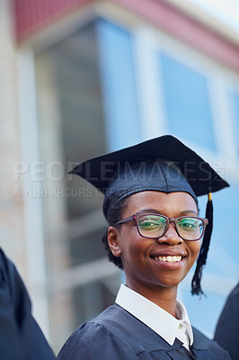 Buy stock photo Portrait of a happy female student standing outside on her graduation day