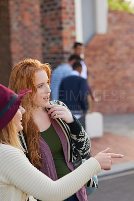 Buy stock photo Cropped shot of two university students hanging out between class