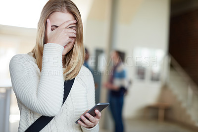 Buy stock photo Cropped shot of a university student covering her face