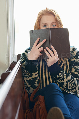 Buy stock photo Portrait of a university student holding a notebook in front of her face