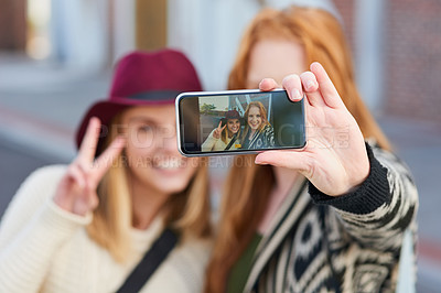 Buy stock photo Cropped shot of two university students taking a selfie together on campus