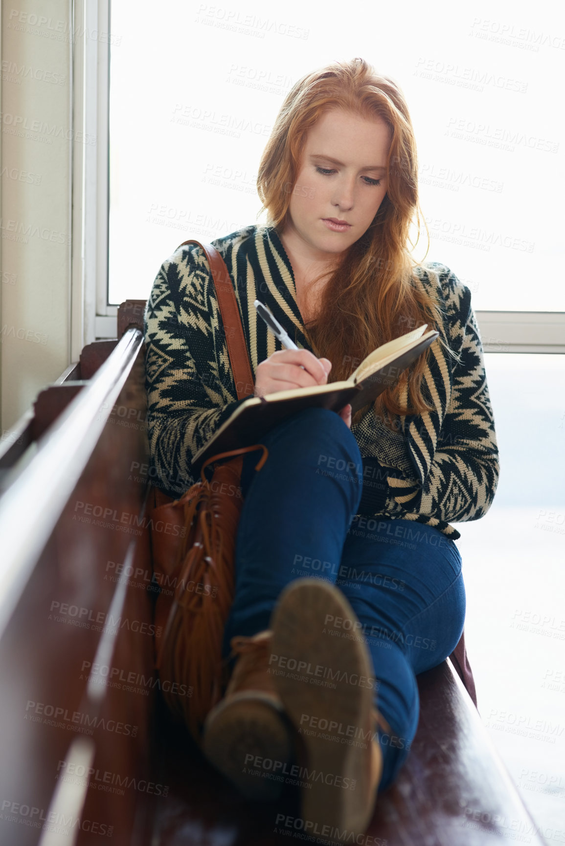 Buy stock photo Shot of a university student writing in her notebook on campus