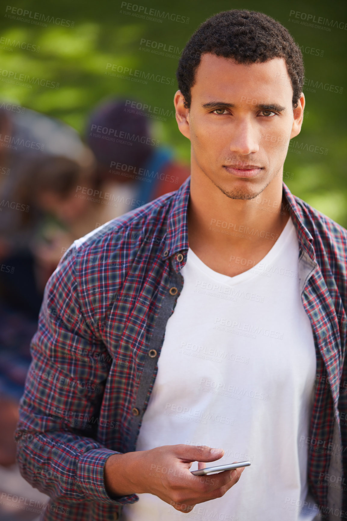 Buy stock photo Shot of a young man using his phone on campus