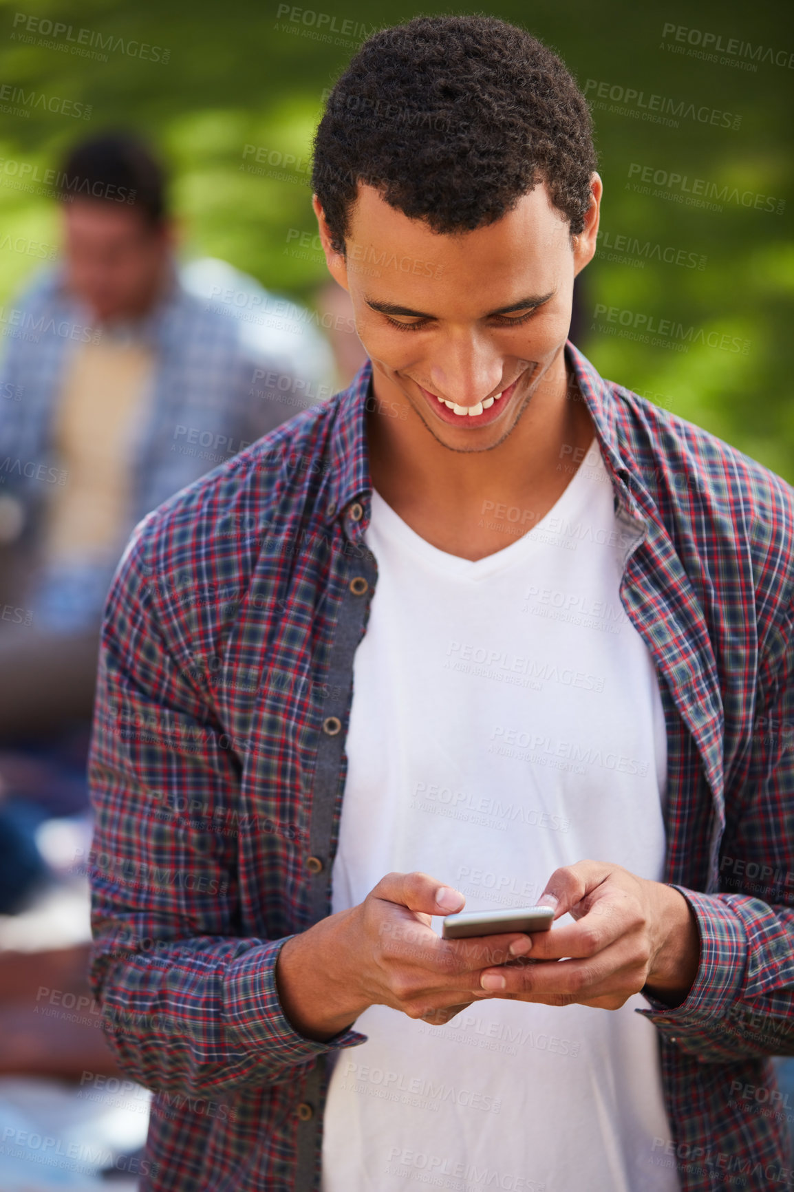 Buy stock photo Shot of a young man using his phone on campus