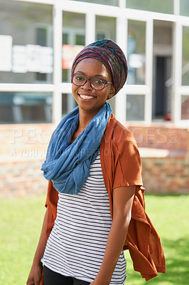 Buy stock photo Portrait of a happy young woman standing outside on campus grounds