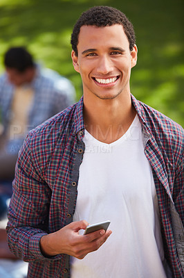 Buy stock photo Shot of a young man using his phone on campus