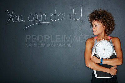 Buy stock photo Shot of a woman holding a scale against a chalk background with a motivational message