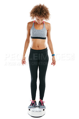 Buy stock photo Shot of a young woman weighing herself against a white background