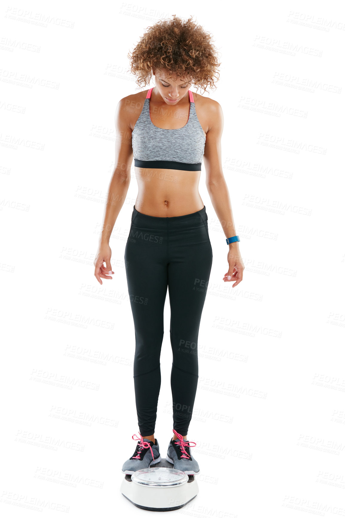 Buy stock photo Shot of a young woman weighing herself against a white background