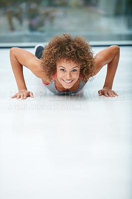 Buy stock photo Shot of a fit young woman doing push-ups in a studio